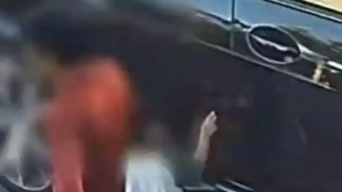 男孩用牙签划车 家长站旁边不管