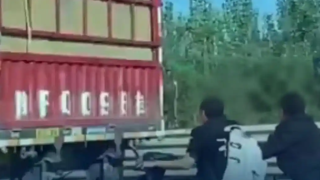 2人骑电动车紧跟大挂车“破风”