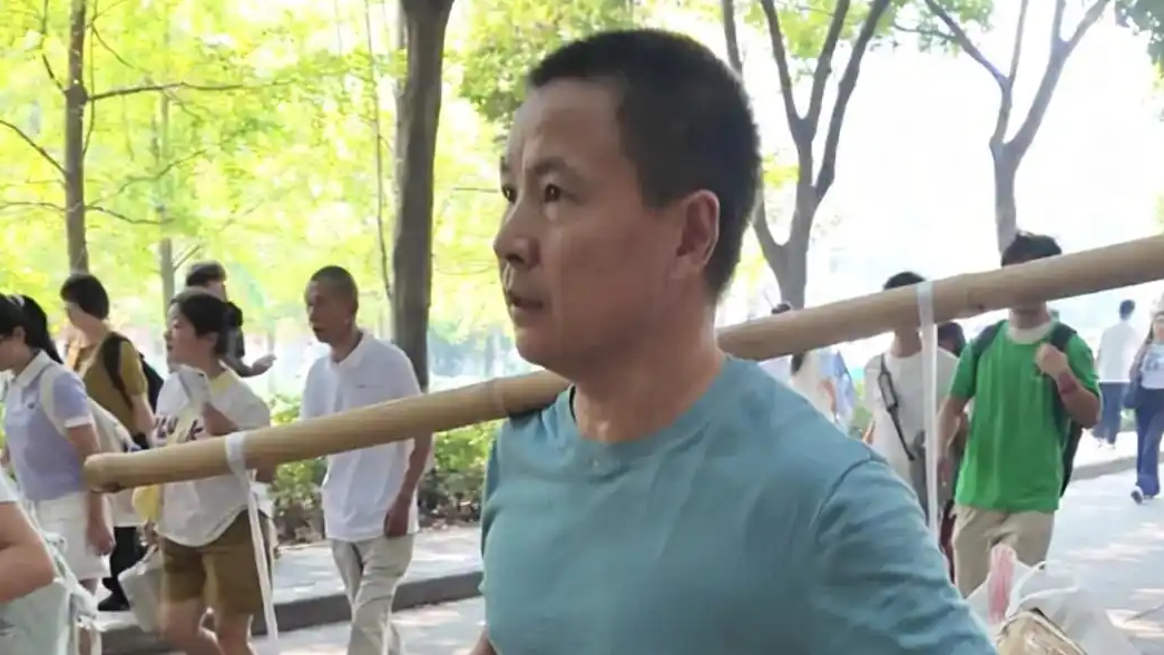 父亲挑扁担送双胞胎姐妹上大学