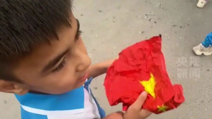 新疆小学生拾起地上国旗护在胸前，“国旗不能踩，要好好爱护！”